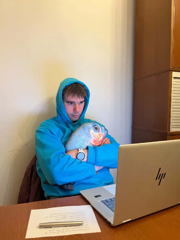 Kursant z pluszową rybą przy laptopie