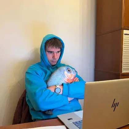 Kursant z pluszową rybą przy laptopie